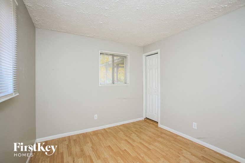 a bedroom with wood floors and white walls and a white door