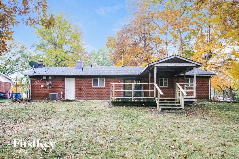 front view of a red brick house with trees in the background