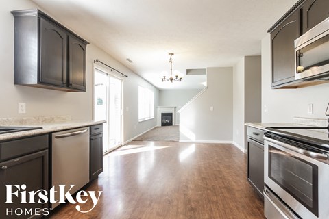 A kitchen with a stainless steel oven and wooden floors.