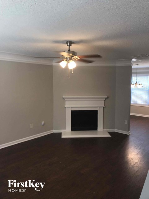 a living room with a fireplace and a ceiling fan