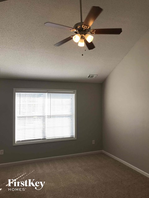 a bedroom with a ceiling fan and a window