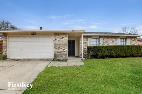 a home with a white garage door and a lawn