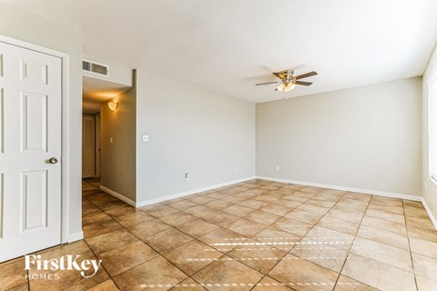 a empty living room with a ceiling fan