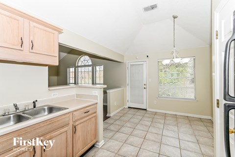 A kitchen with wooden cabinets and a white sink.