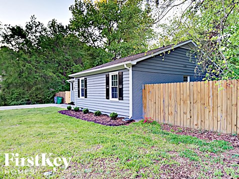 a small blue house with a wooden fence in front of it