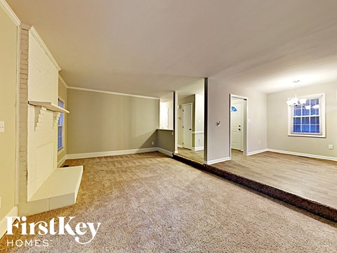 an empty living room with a wood floor and white walls
