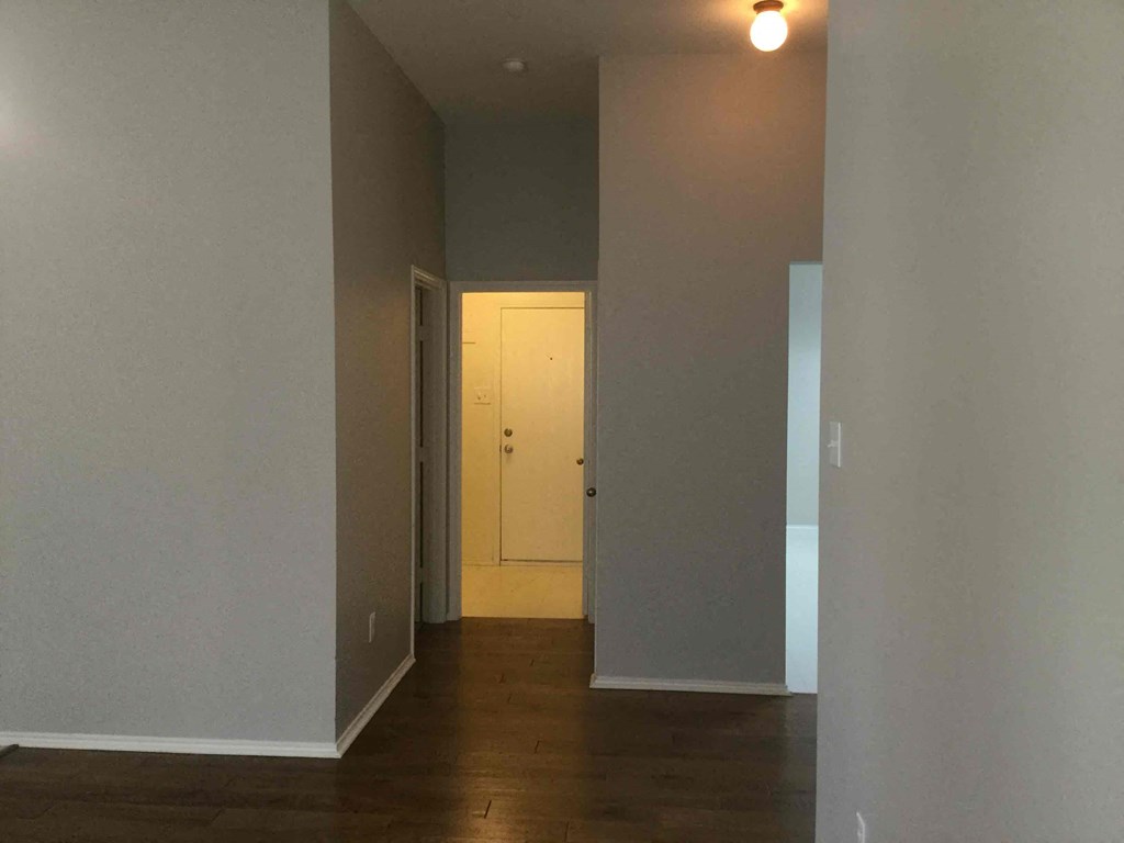 a hallway with a white door and wood floors