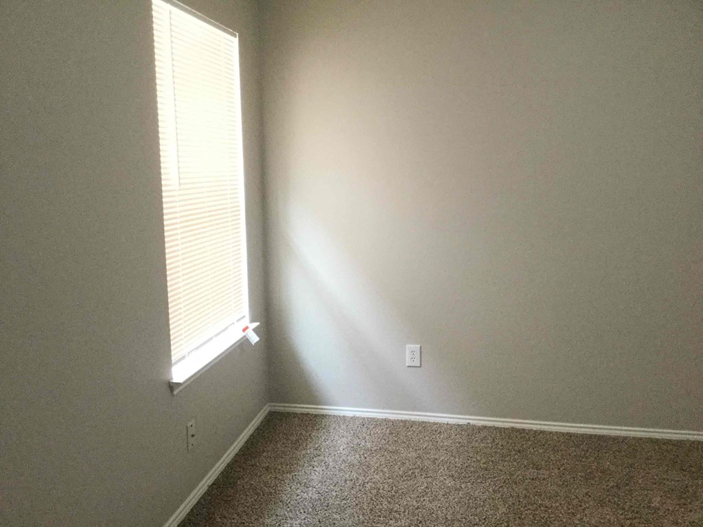a room with a window and a carpeted floor
