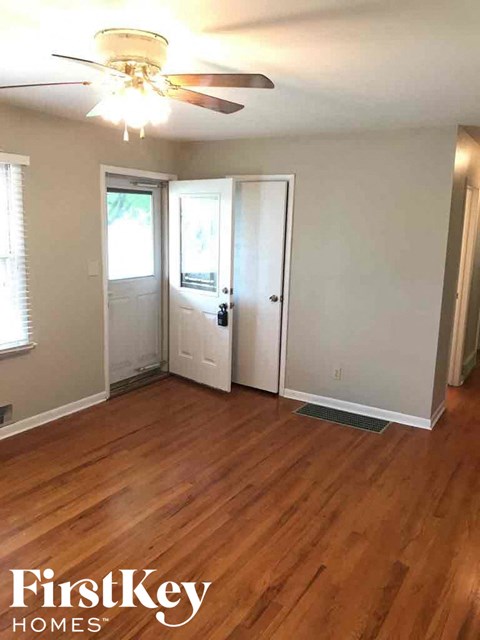 A room with wood floors and a ceiling fan.