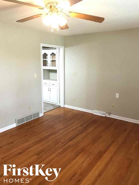 A room with wooden floors and a ceiling fan.