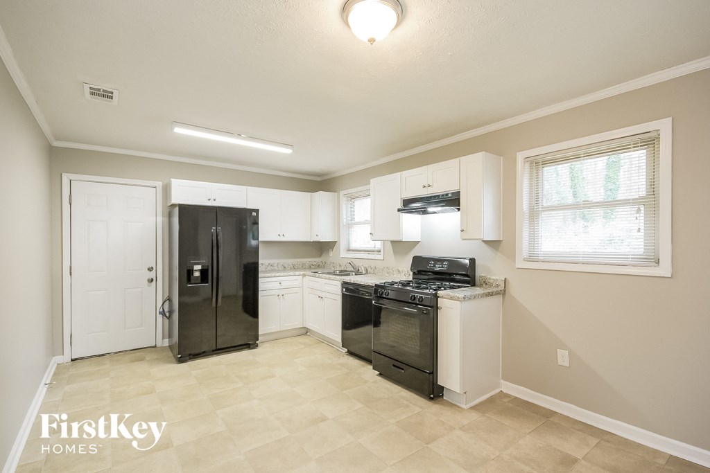 a kitchen with black appliances and white cabinets