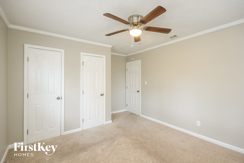 a bedroom with two closets and a ceiling fan