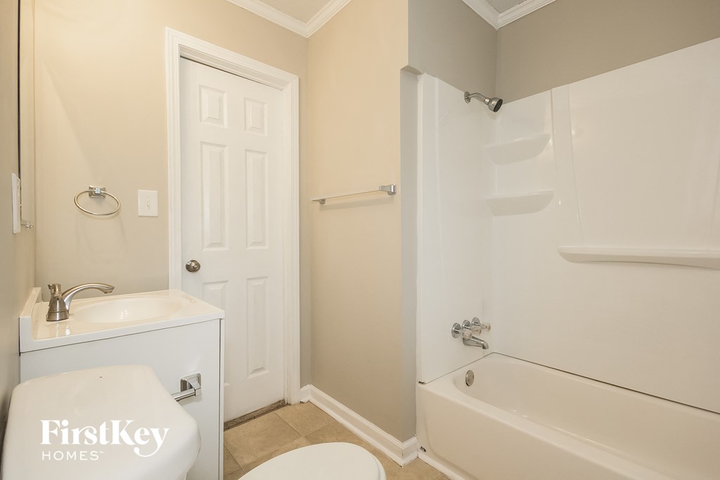 a bathroom with a toilet and a tub and a sink