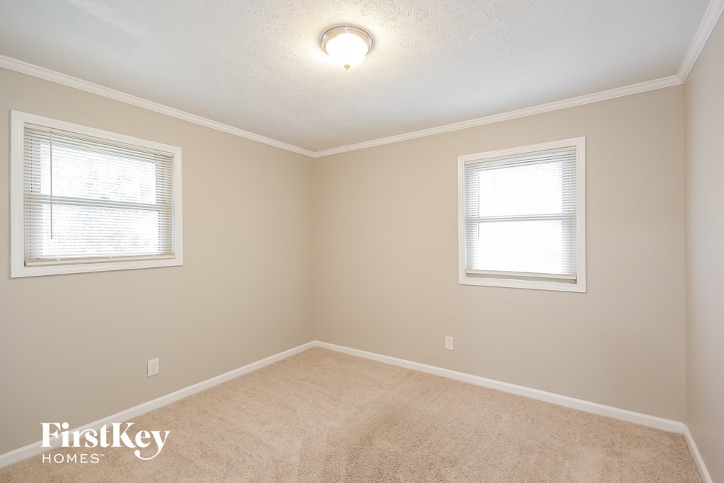 a empty room with two windows and a carpet