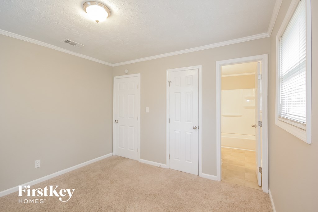 a bedroom with two closets and a door to a bathroom
