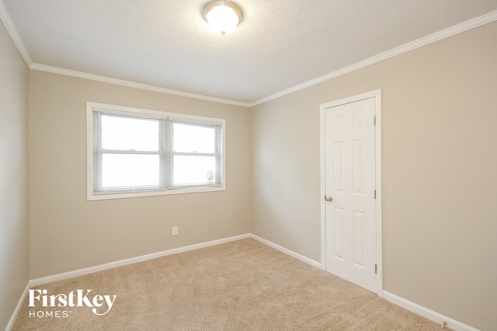 a bedroom with a white door and a window