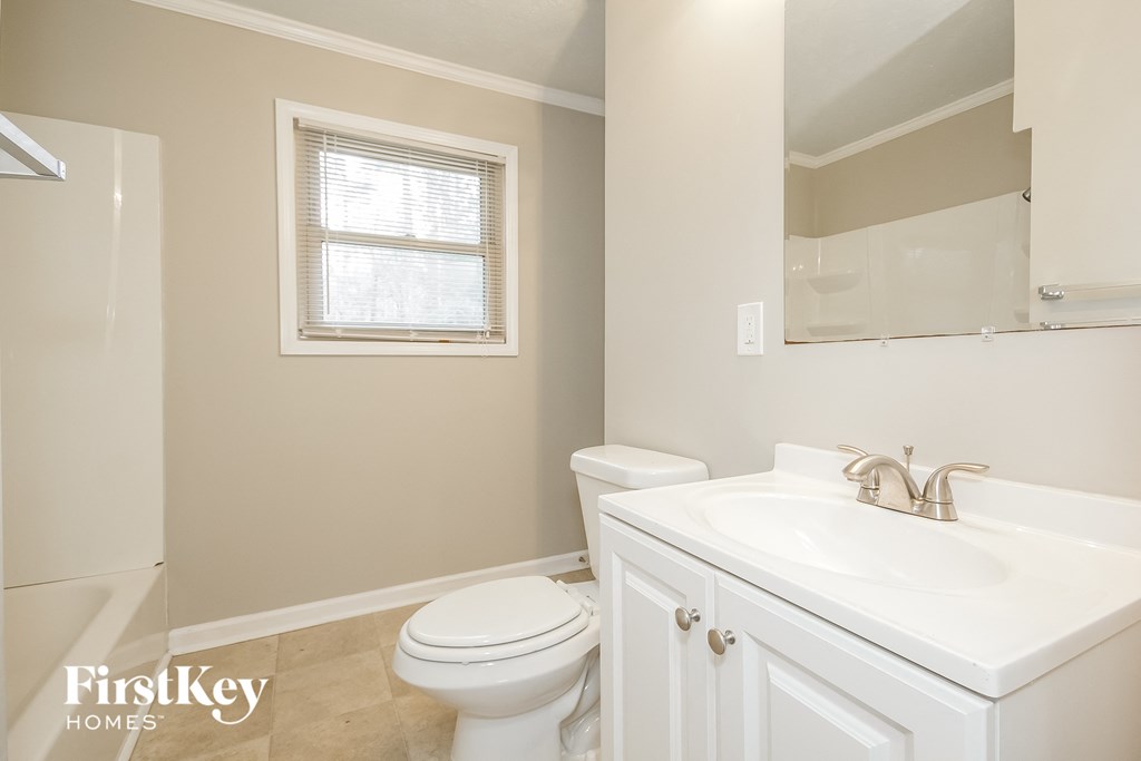 a bathroom with a sink toilet and a mirror