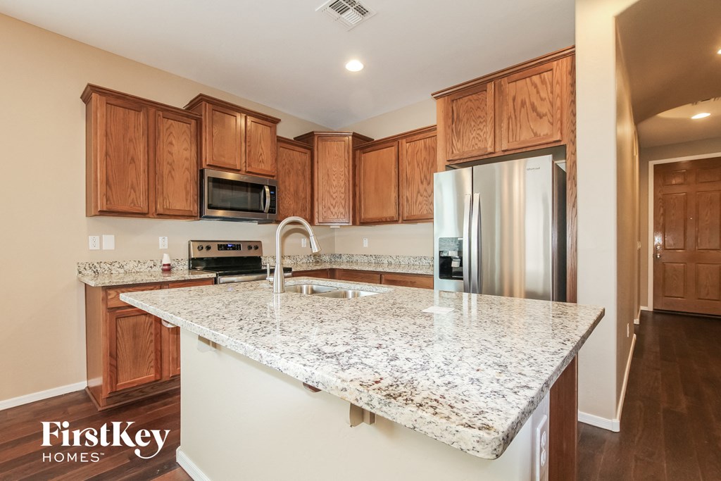 a kitchen with granite counter tops and wooden cabinets