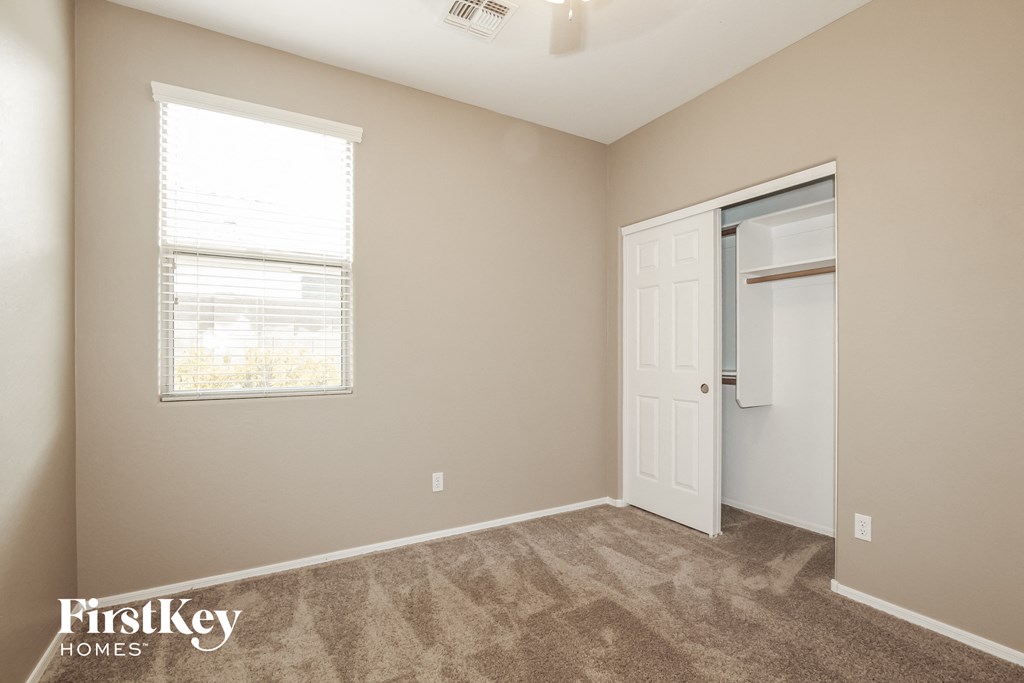 a bedroom with a closet and a window and a white door