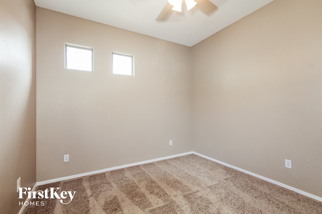 the spacious living room with carpeting and a ceiling fan