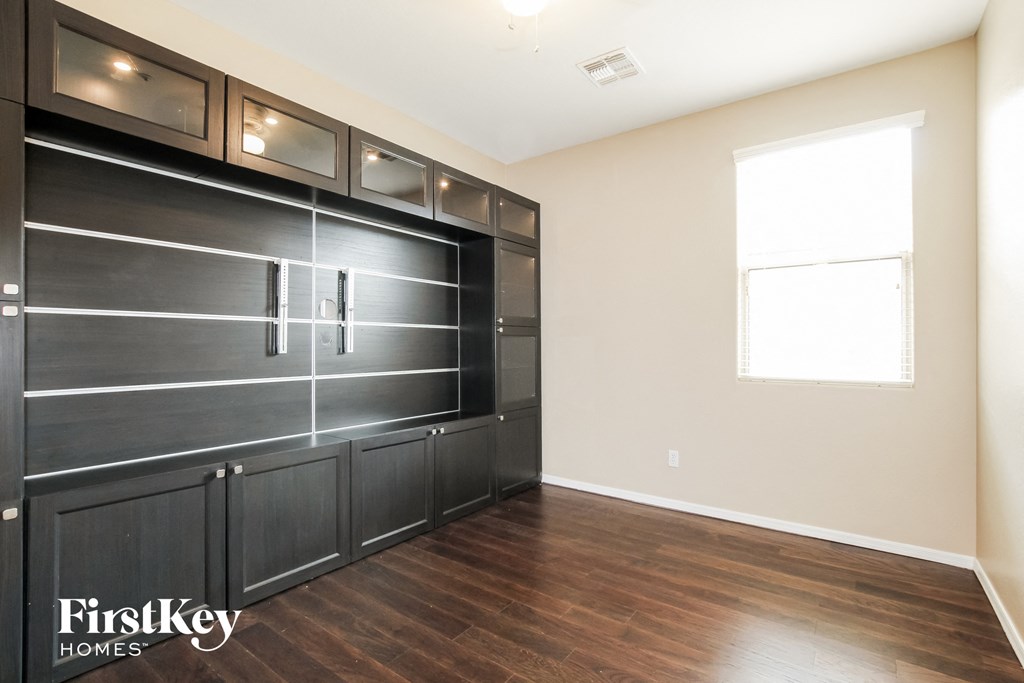 the garage of this home has a large black garage door and wood flooring
