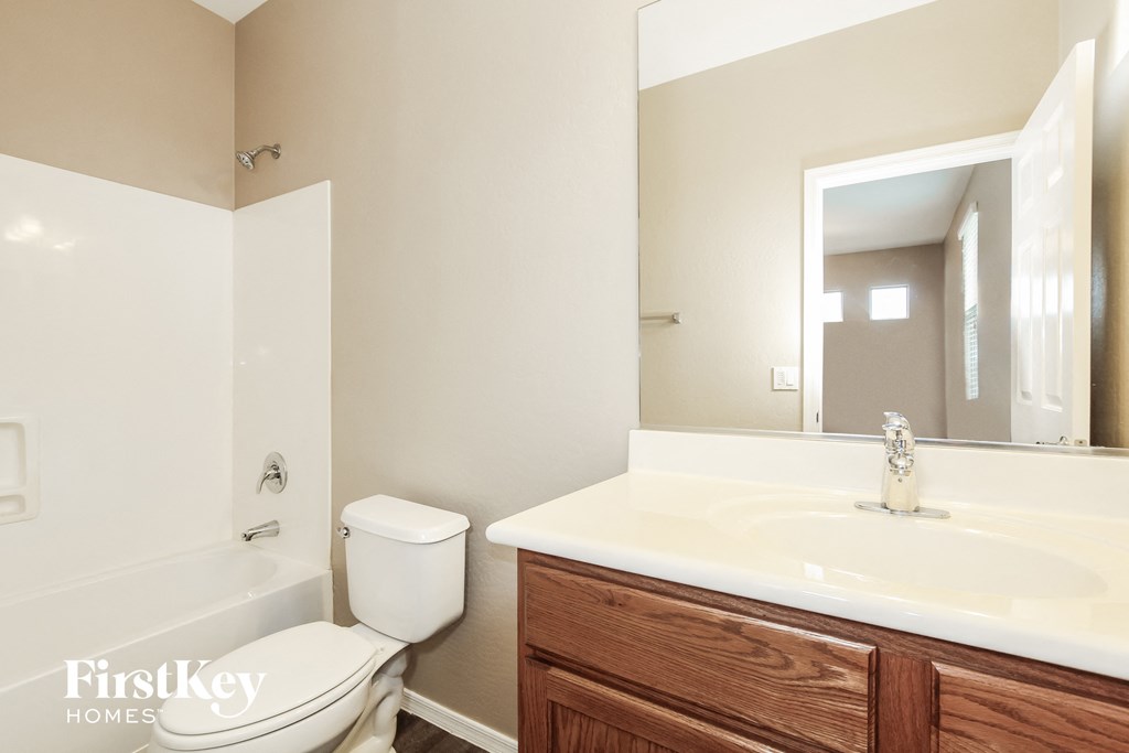a bathroom with a large mirror and a sink and a toilet