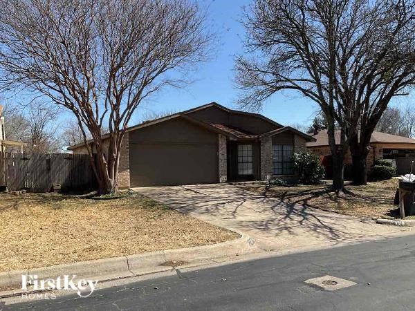 A house with a brown roof and a driveway in front.