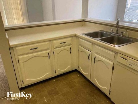 A kitchen with white cabinets and a sink.
