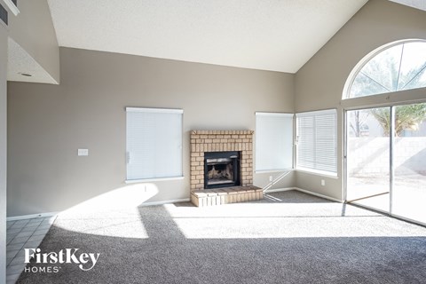 A living room with a fireplace and a carpet on the floor.