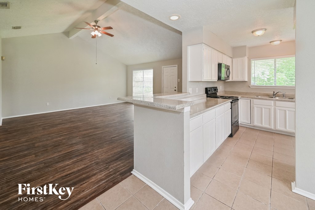 an open kitchen and living room with a ceiling fan