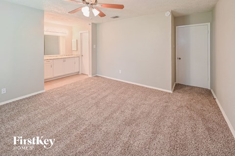 a living room with carpet and a ceiling fan