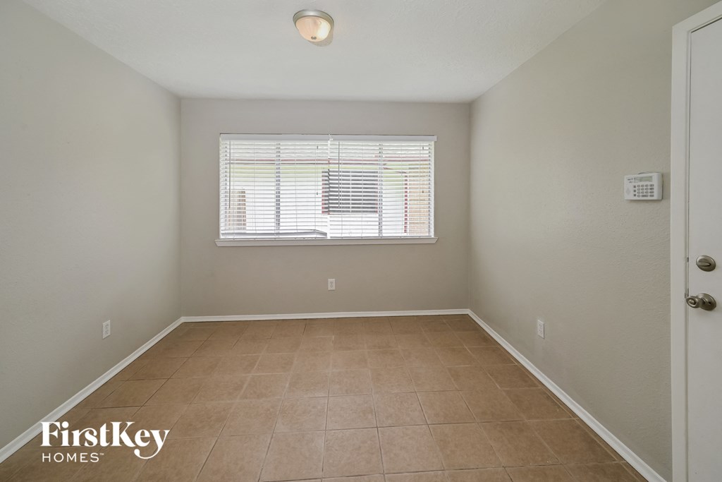 the spacious dining room with a window and tiled floors