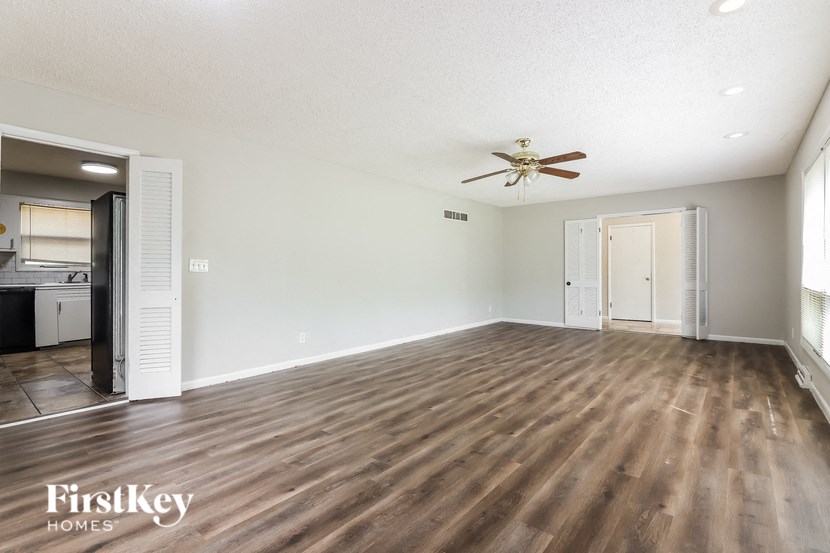 an empty living room with a ceiling fan