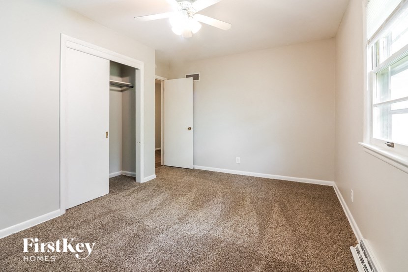 a bedroom with a carpeted floor and a closet