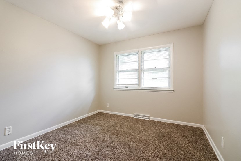 an empty room with a window and a carpet