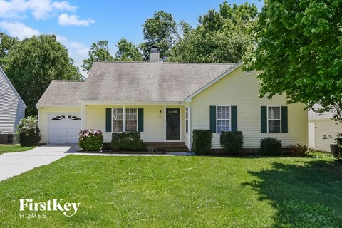 a white house with black shutters and a lawn