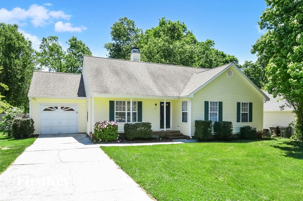 a white house with a white garage door and a lawn