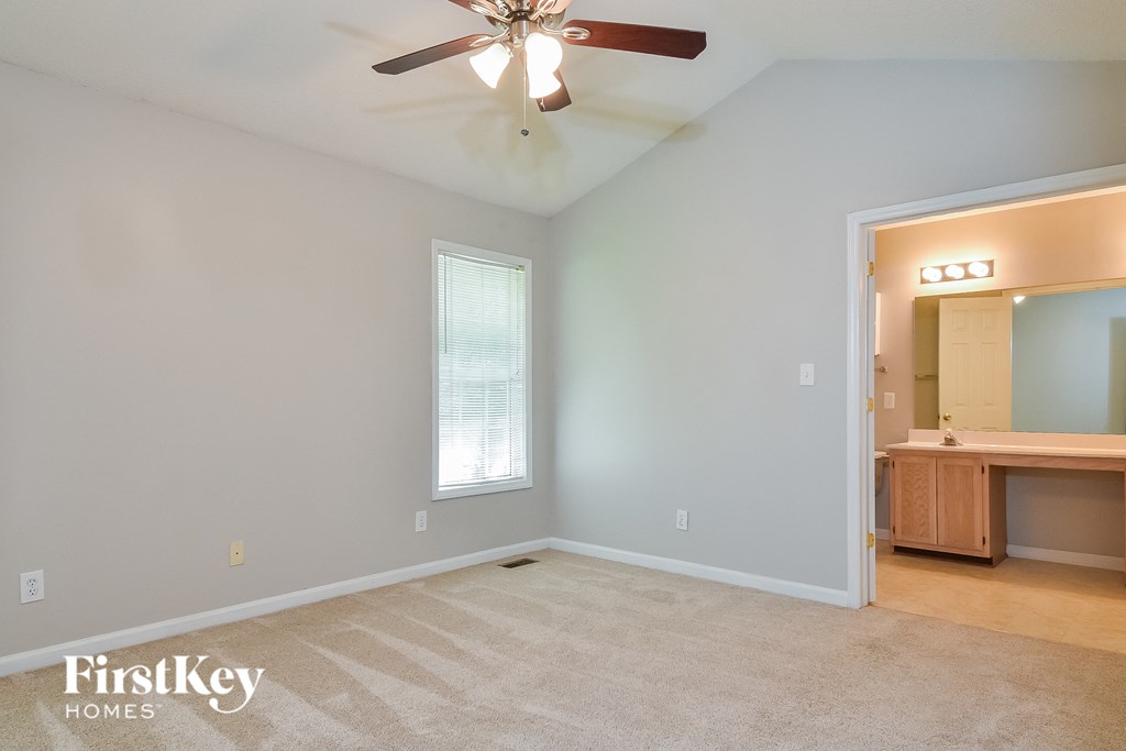 the living room of an empty house with a ceiling fan