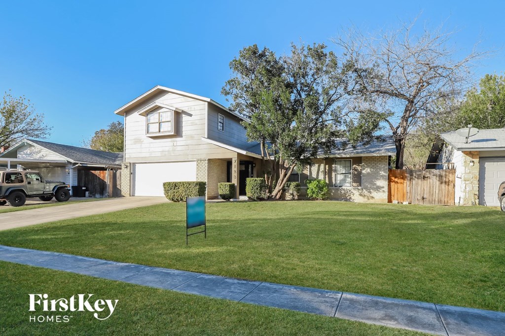 a home with a lawn and a blue mailbox in front of it