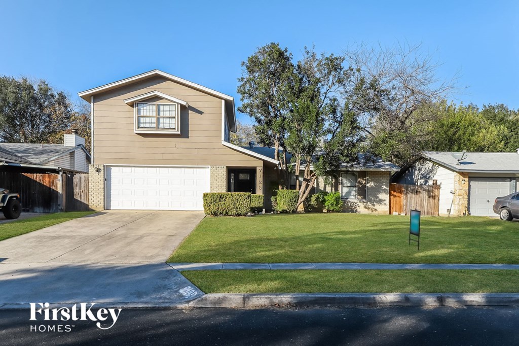 a house with a white garage door and a lawn