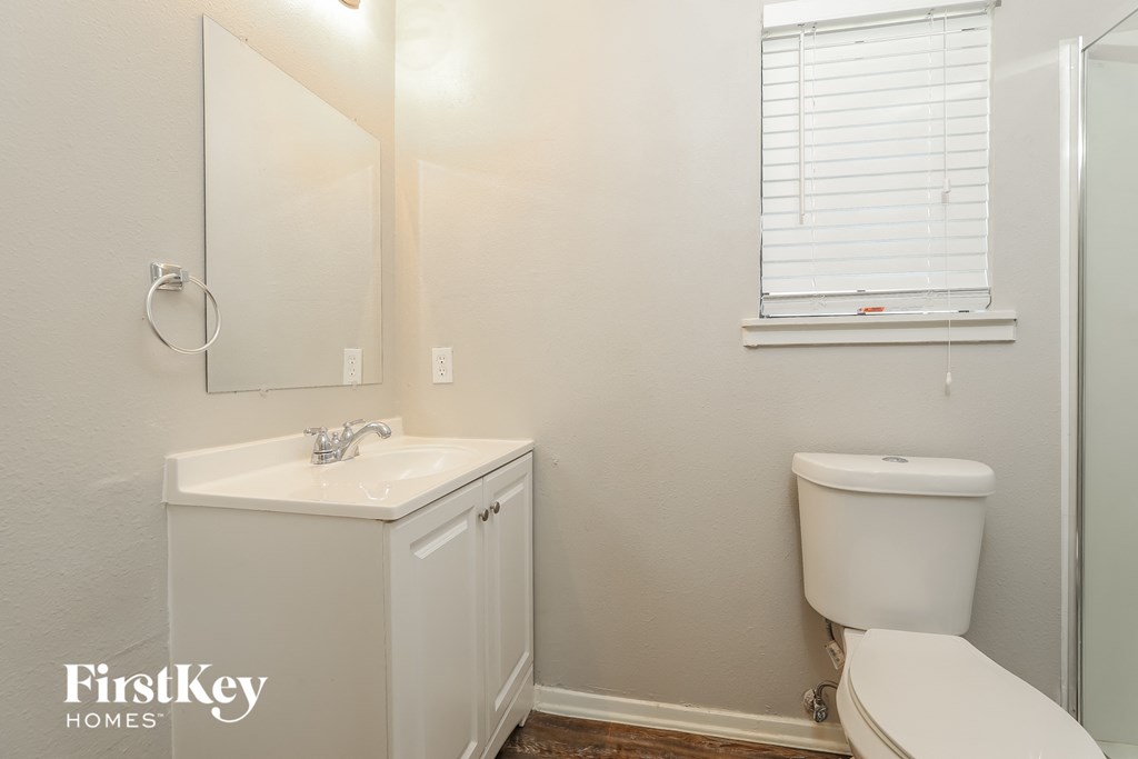 a bathroom with a toilet and a sink and a mirror