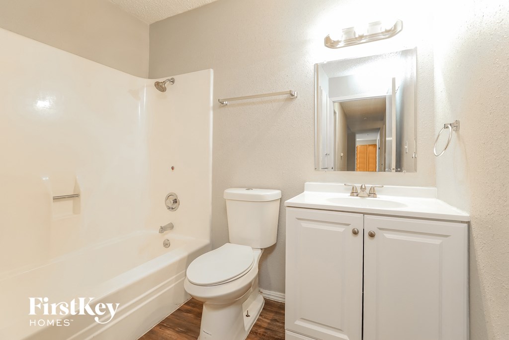 a bathroom with a toilet sink and shower and a mirror