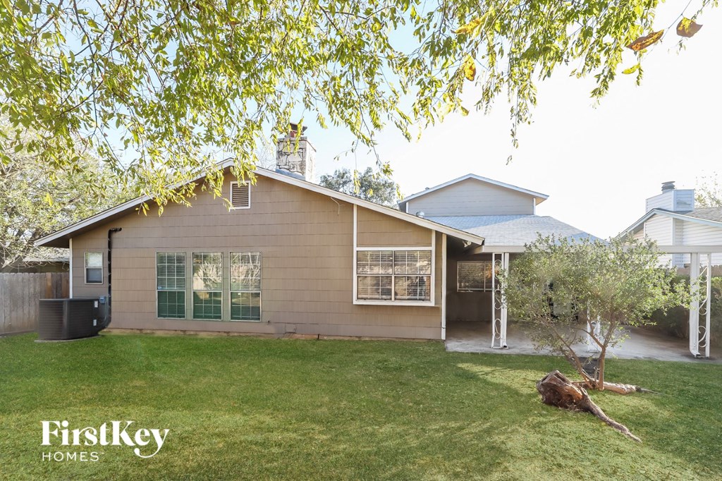 the exterior of a house with a yard and a tree