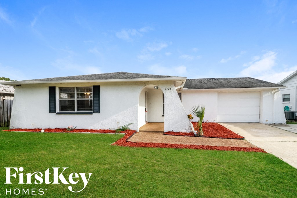 a white house with a yard and grass