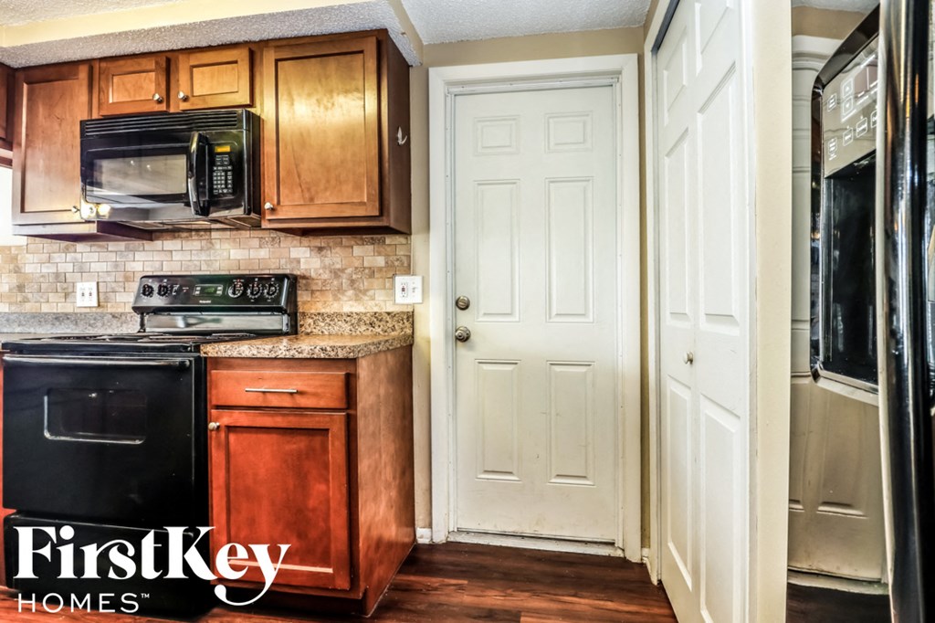 a kitchen with wood cabinets and a white door