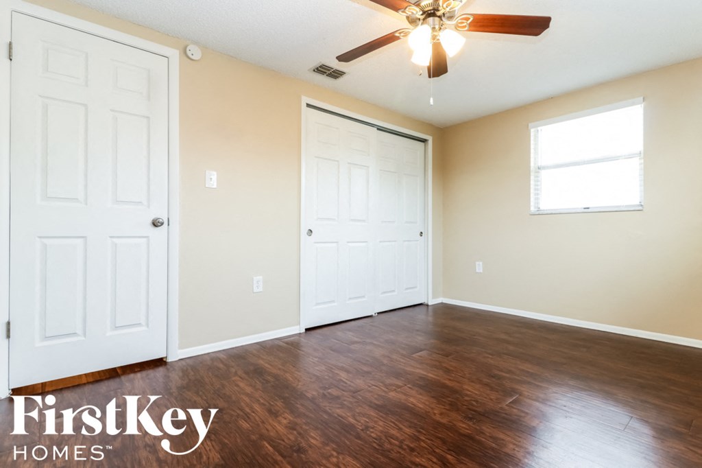 a living room with wood flooring and a ceiling fan