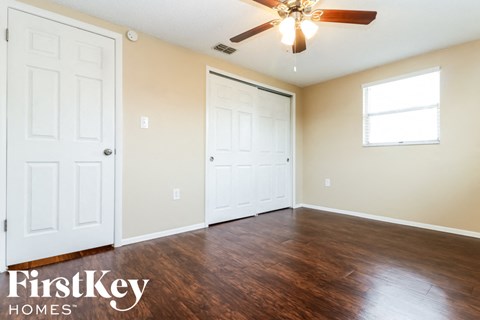 a living room with wood flooring and a ceiling fan