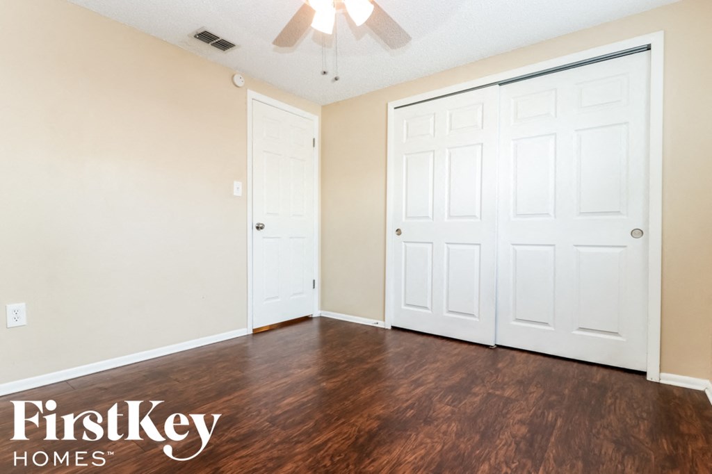 the living room with two closets and a ceiling fan