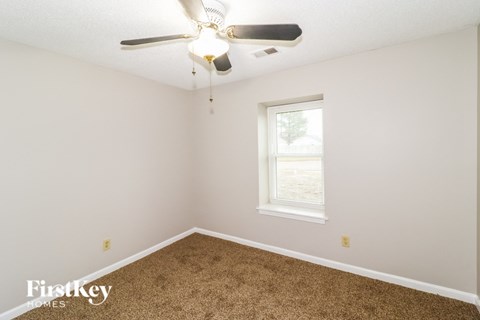 a bedroom with carpet and a ceiling fan