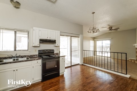 A kitchen with white cabinets and a black stove top oven.